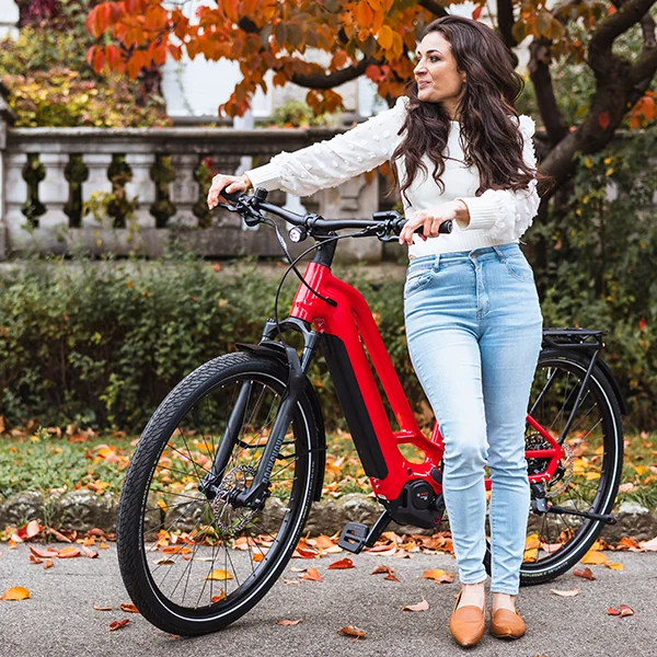 Dunkelhaarige Frau lehnt an das loretta rote Cresta eGiro GT.